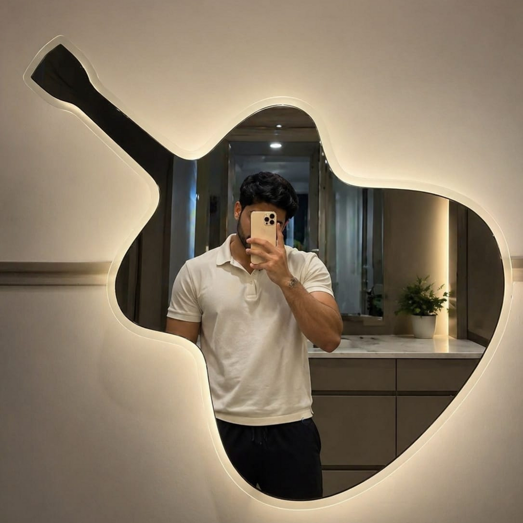 Person taking a mirror selfie in a guitar-shaped light fixture.